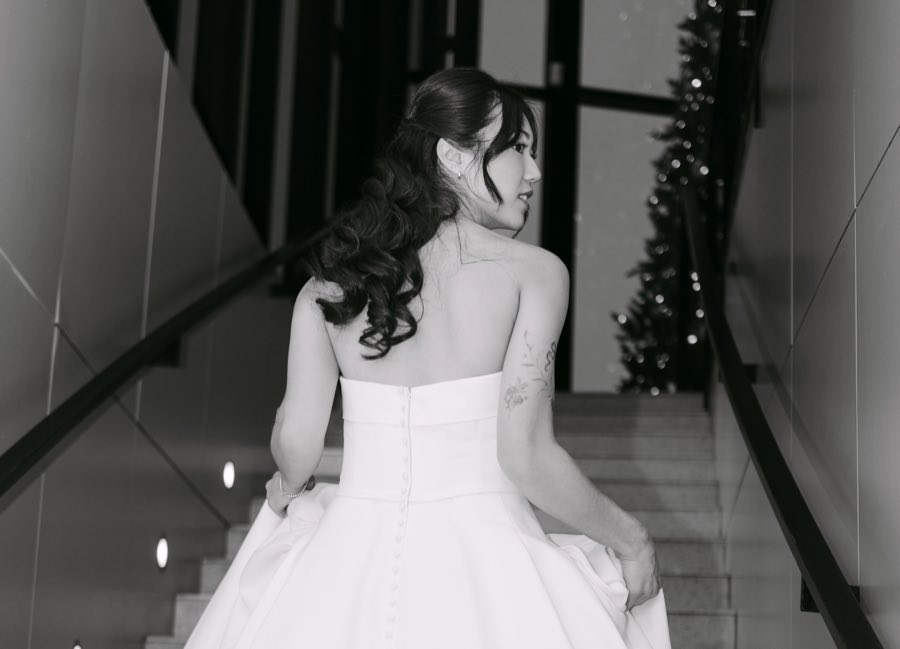 A bride looking back over her shoulder on a staircase