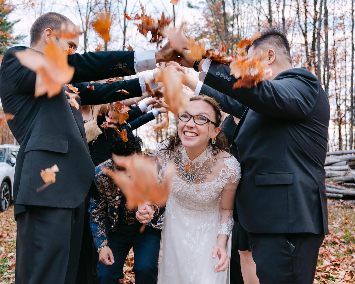 A wedding party throwing autumn leaves, caught mid-motion
